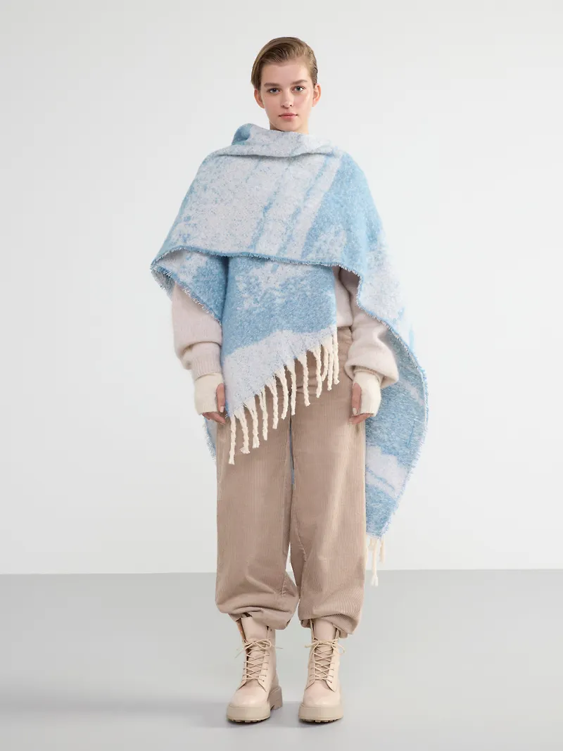 Stickad poncho med fransar