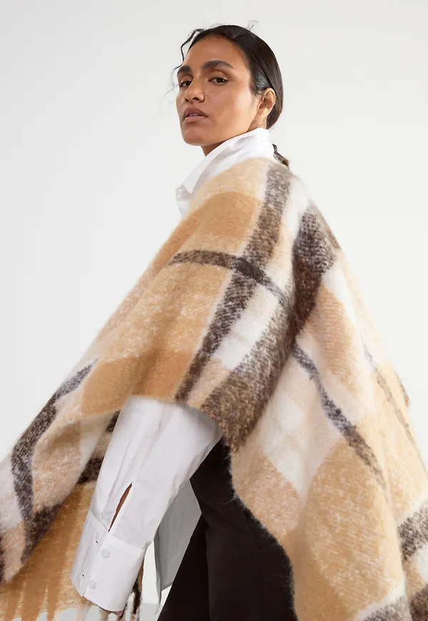 Stickad poncho med fransar