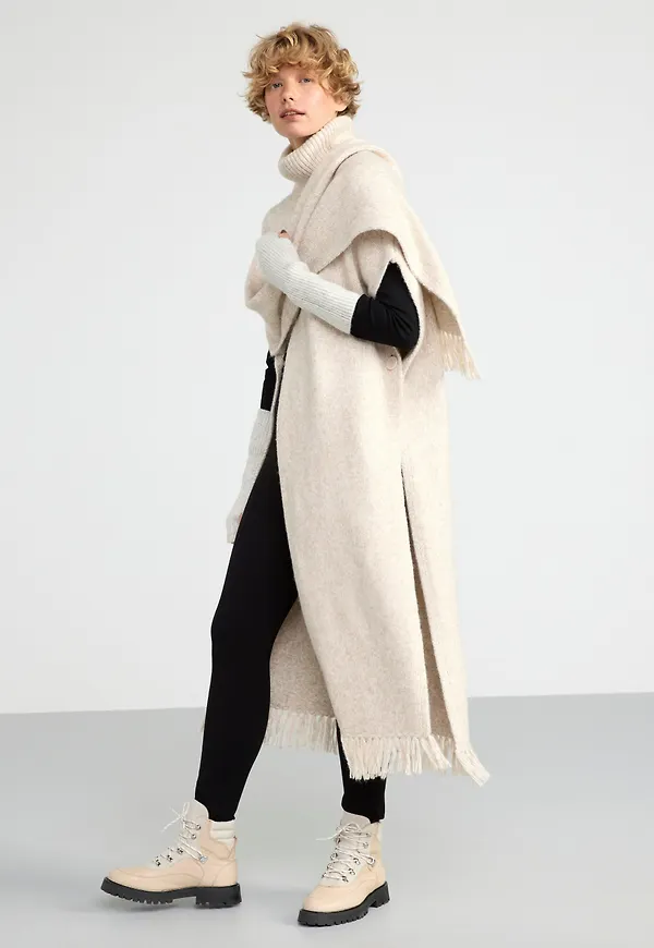 Stickad poncho med polokrage
